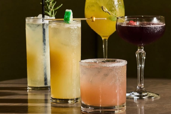 variety of happy hour cocktails arranged on a table